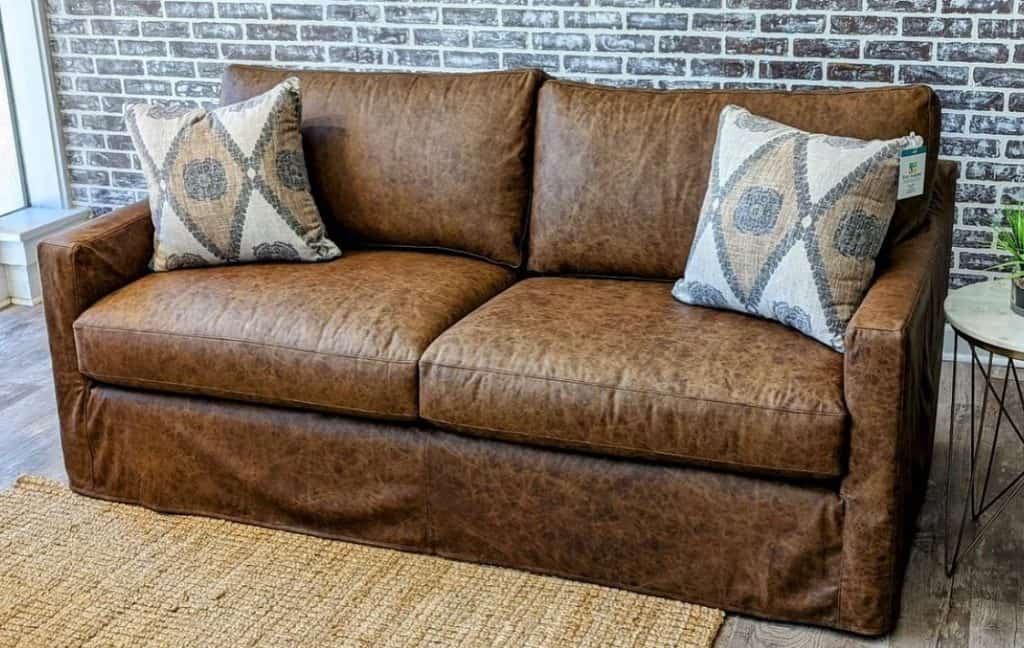 Brown_Leather_Couch_Against_a_Brick_Wall_