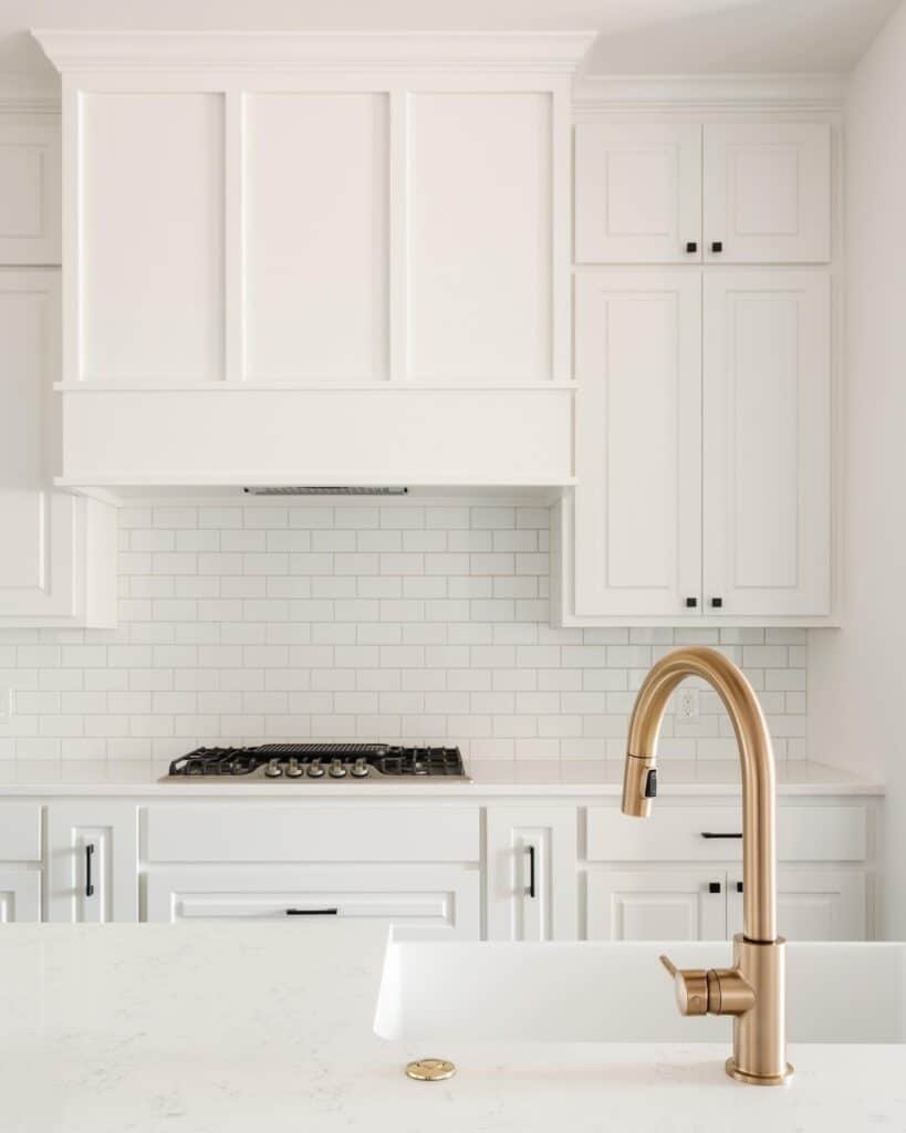 A_White_Tiled_Bathroom_With_a_Sink_and_S_